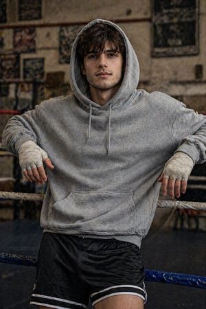 Gritty Boxer Leaning on Ring Ropes