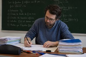 Math Teacher Grading Papers in Classroom